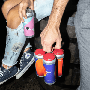 Two people are holding cans of drinks.