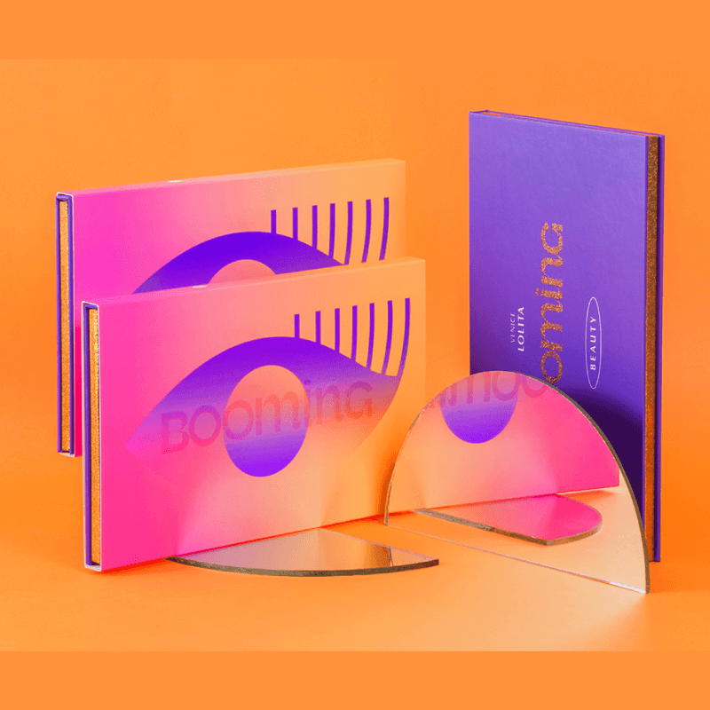 An abstract, colorful display features three gradient pink and orange booklets with stylized eye designs and a reflection.