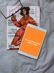 magazine with iPad mockup on a grey bedsheet