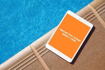 white iPad mockup beside swimming pool